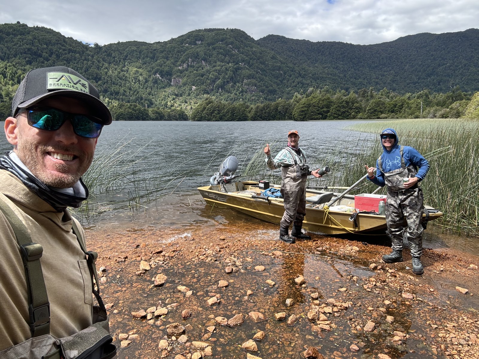 Guide and guests on a Patagonia lake shoreline after a day of fly fishing