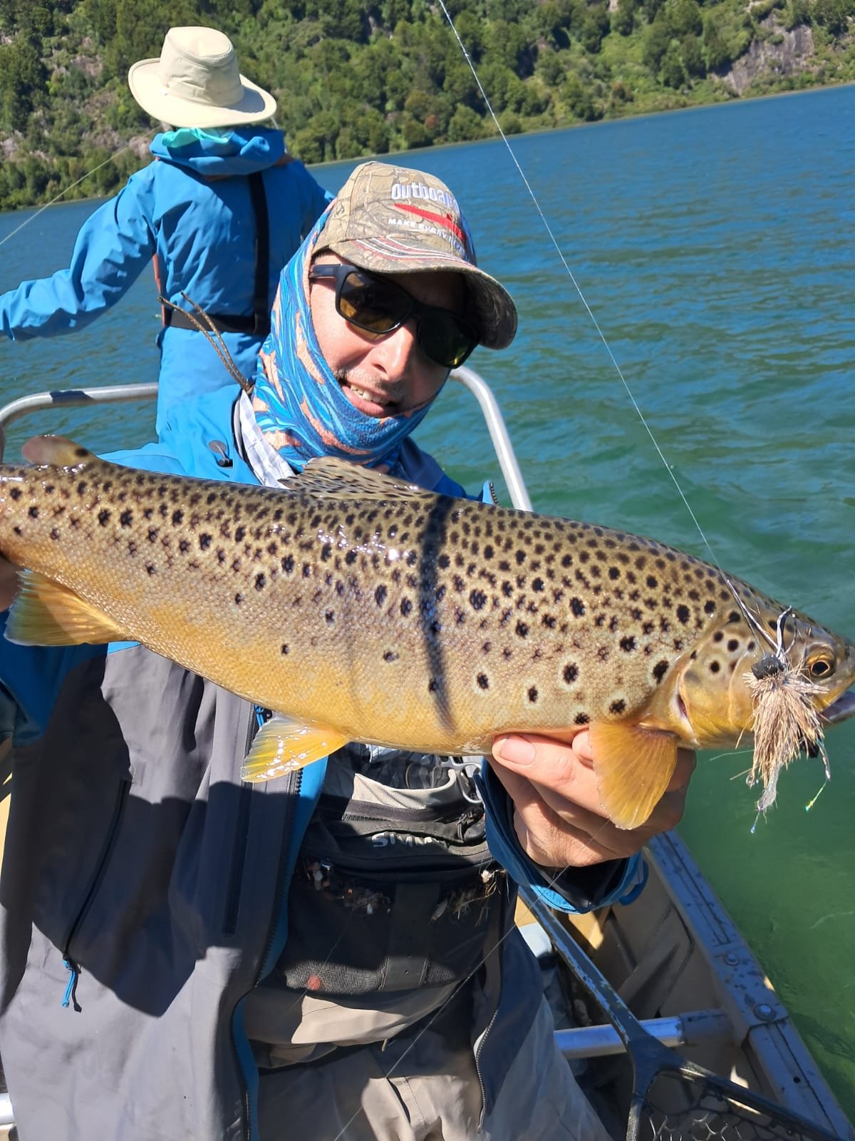 Guest with brown trout taken on a dragon fly pattern on a lake near Coyhaique Chile