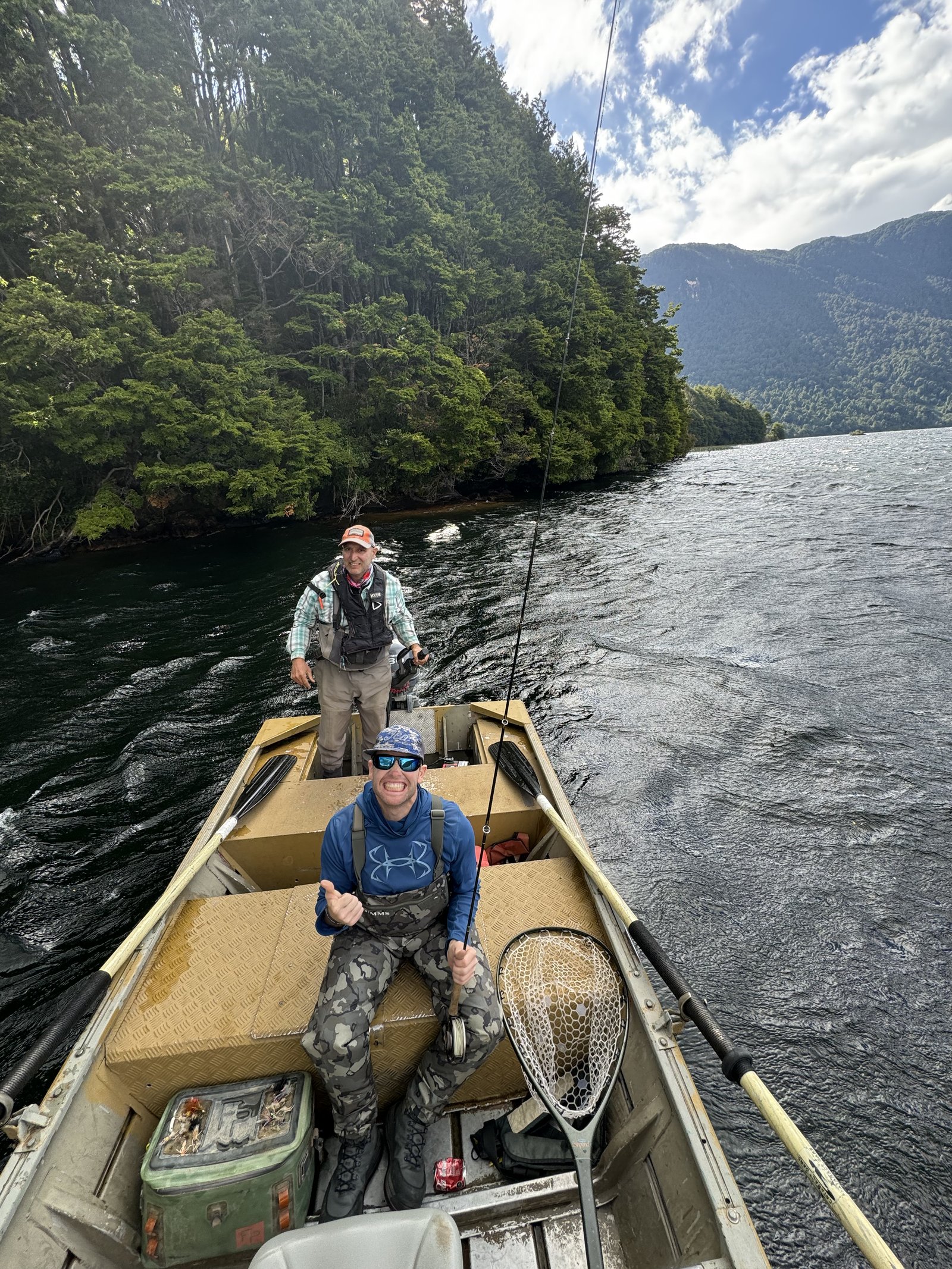 José Marti running a boat with guests on a forested Patagonia river