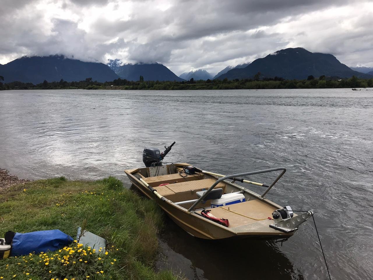 Jet boat on a wide Patagonia river under mountain weather in Chile