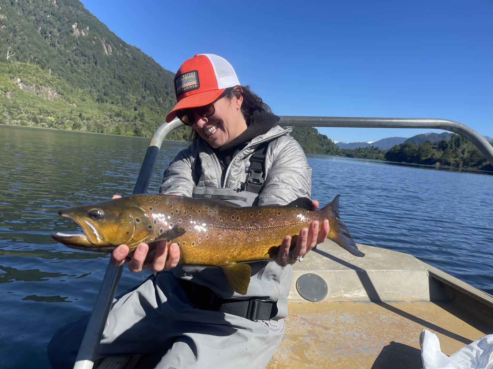 Guest smiling with a large brown trout on a Magic Waters lodge trip in Chile